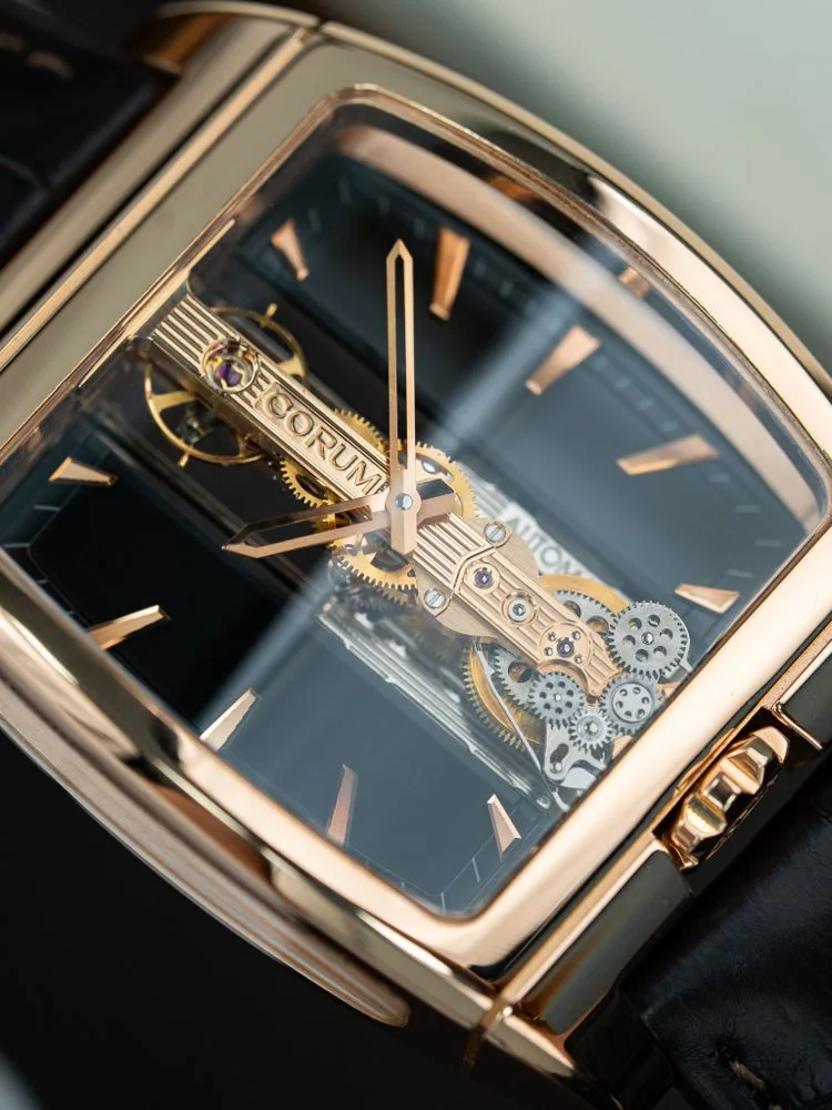 Gold wristwatch with exposed gears Gold mechanical wristwatch with exposed gears and a black leather strap.